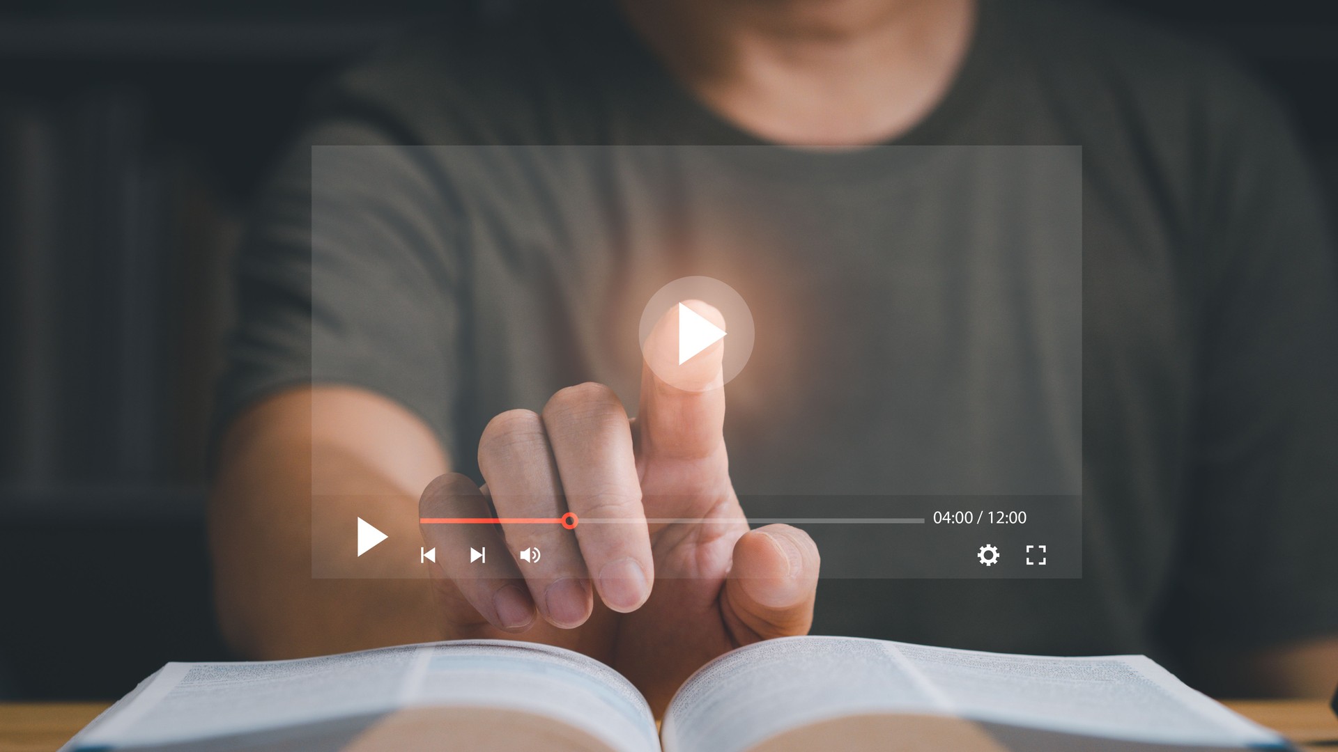 Finger pointing at play button on virtual screen.